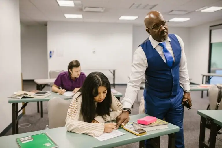 Blog old Teacher monitors students during an exam in a classroom, emphasizing academic integrity.