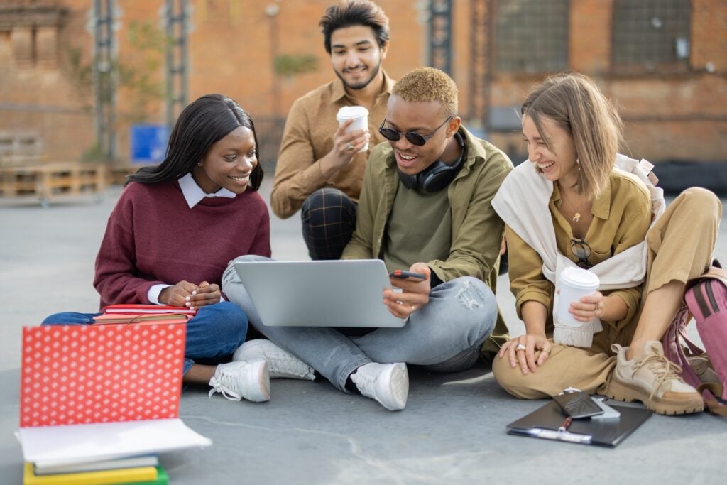 students watching something on laptop on asphalt.jpg